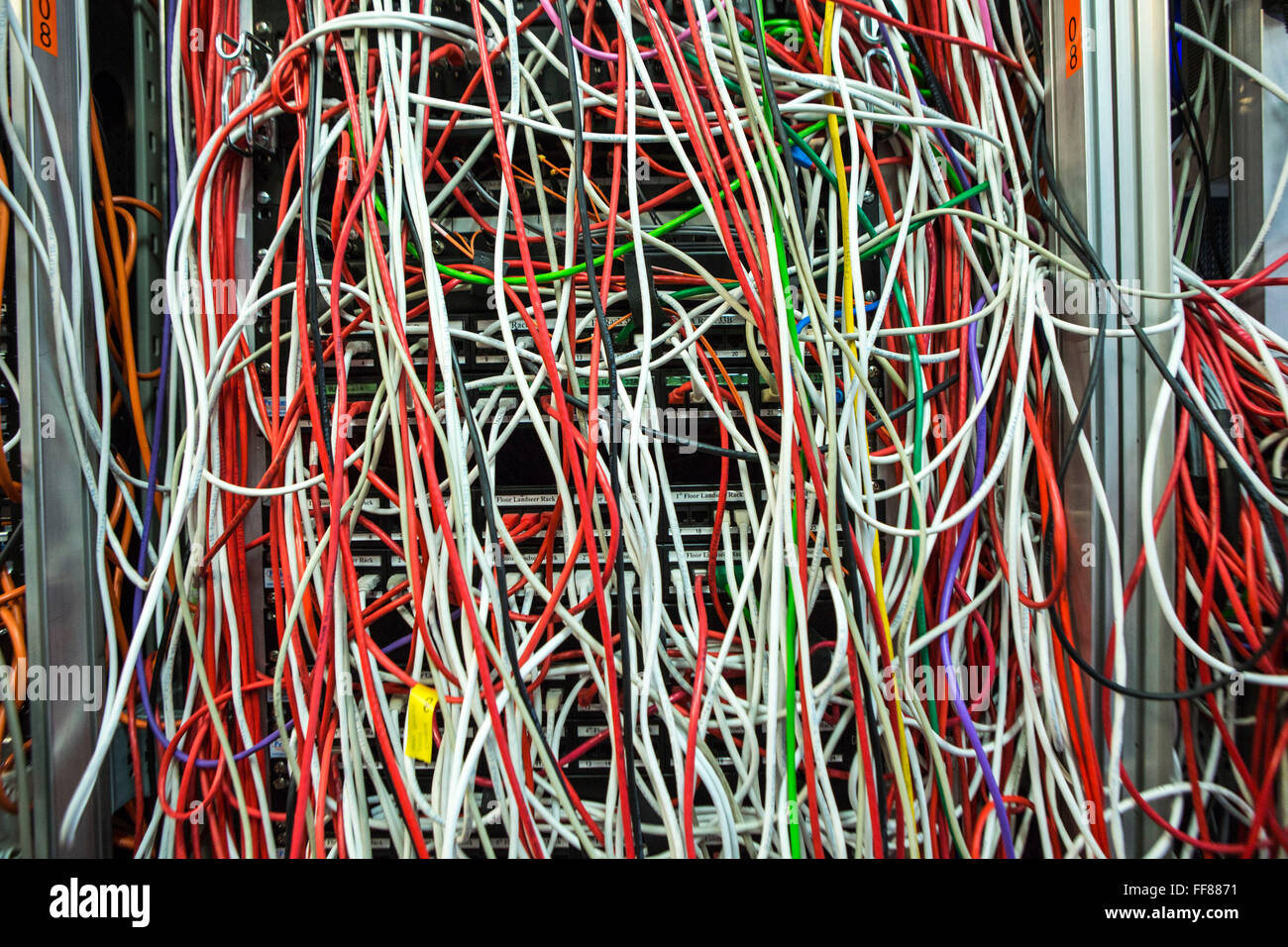 Una grande massa di multi-colore dei cavi del computer in una sala server in un British business office di Londra, Regno Unito. Foto Stock