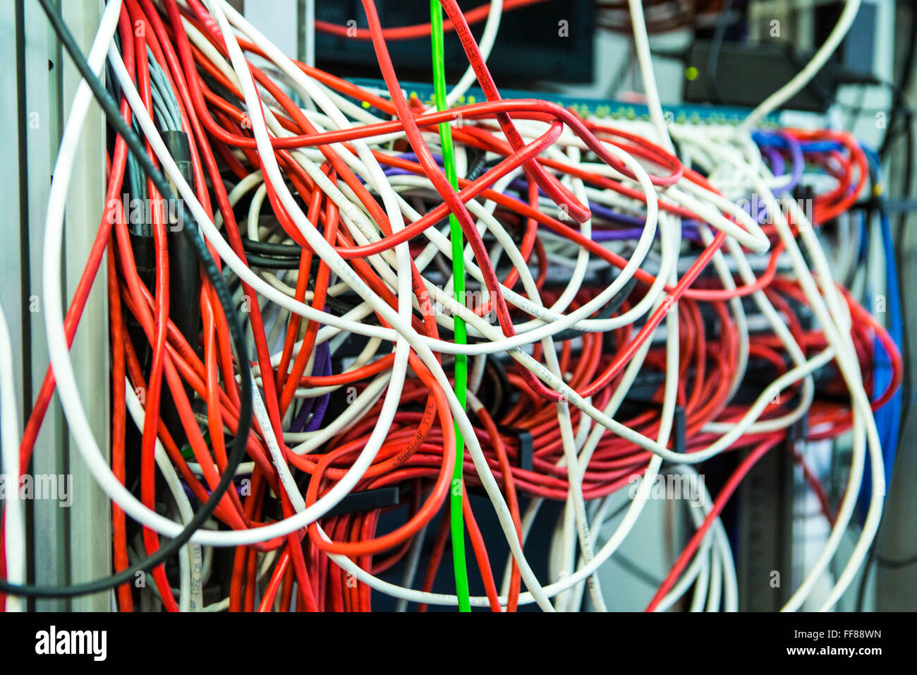 Una grande massa di multi-colore dei cavi del computer in una sala server in un British business office di Londra, Regno Unito. Foto Stock