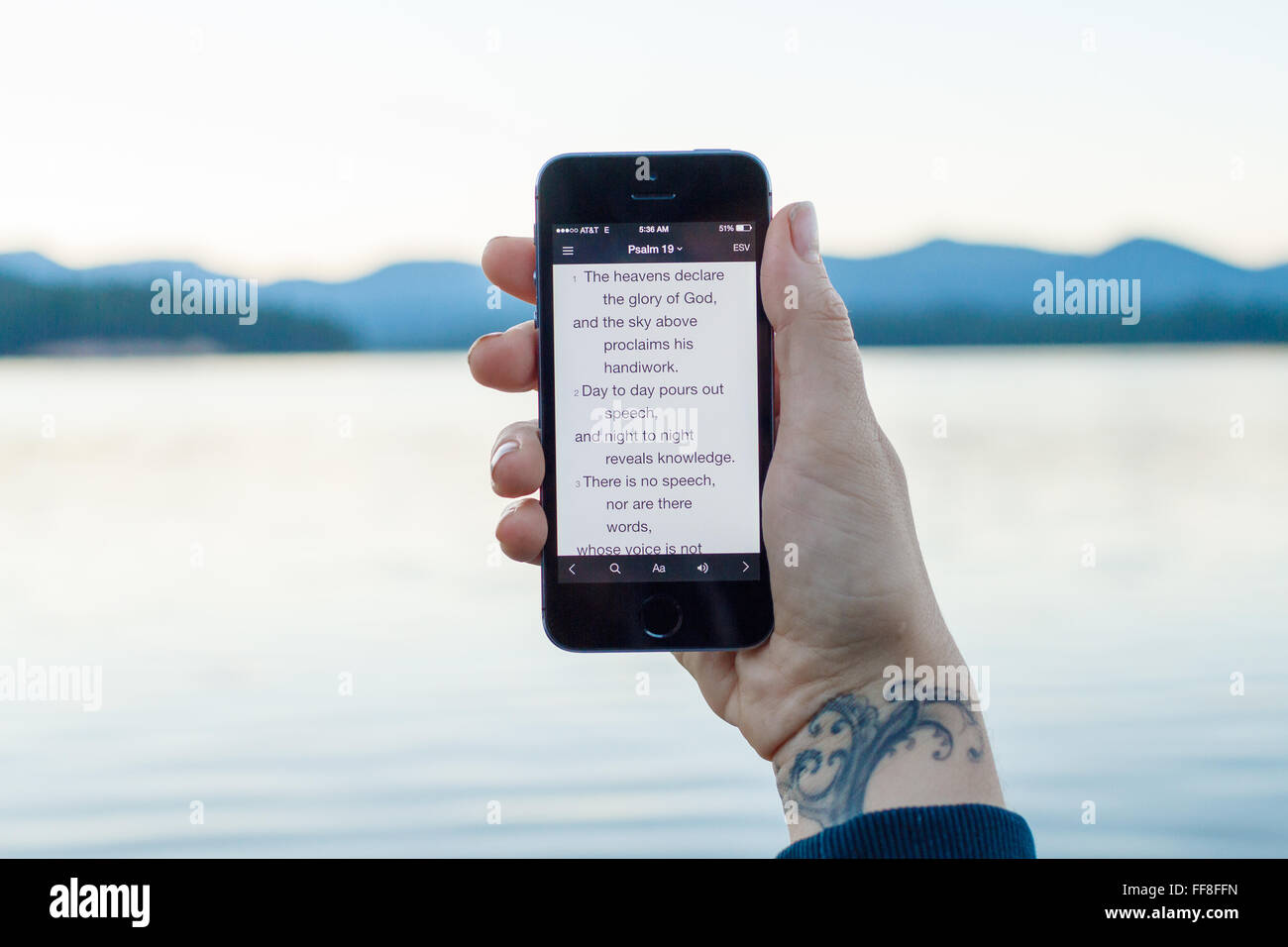Smart phone al lago con il Salmo 19 versetti biblici sullo schermo. Foto Stock