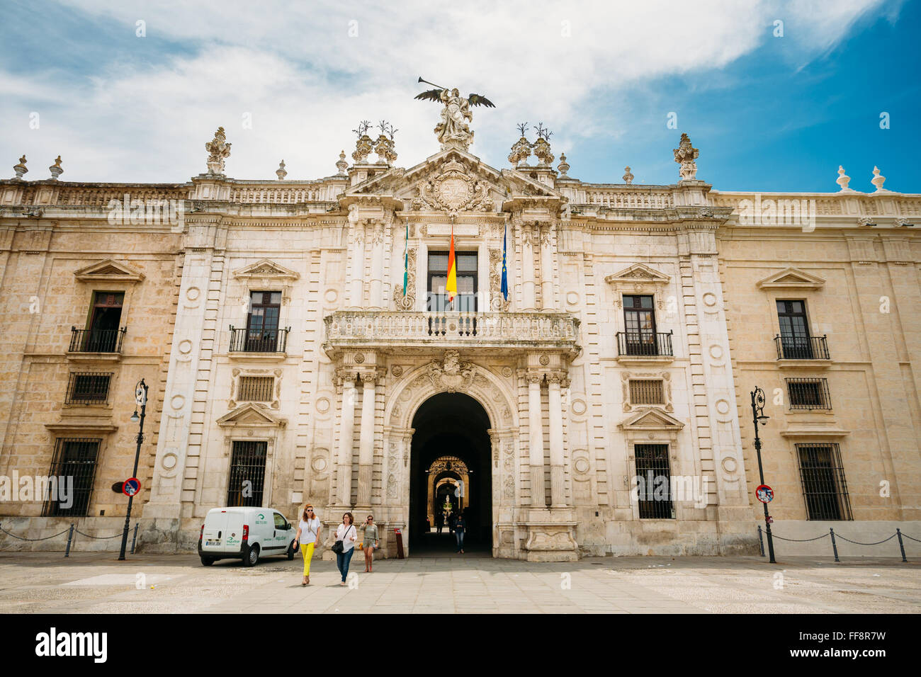 Le persone camminare vicino a facciata principale della vecchia reale fabbrica di tabacco di Siviglia. Ora questo edificio è di proprietà dell'Università Foto Stock