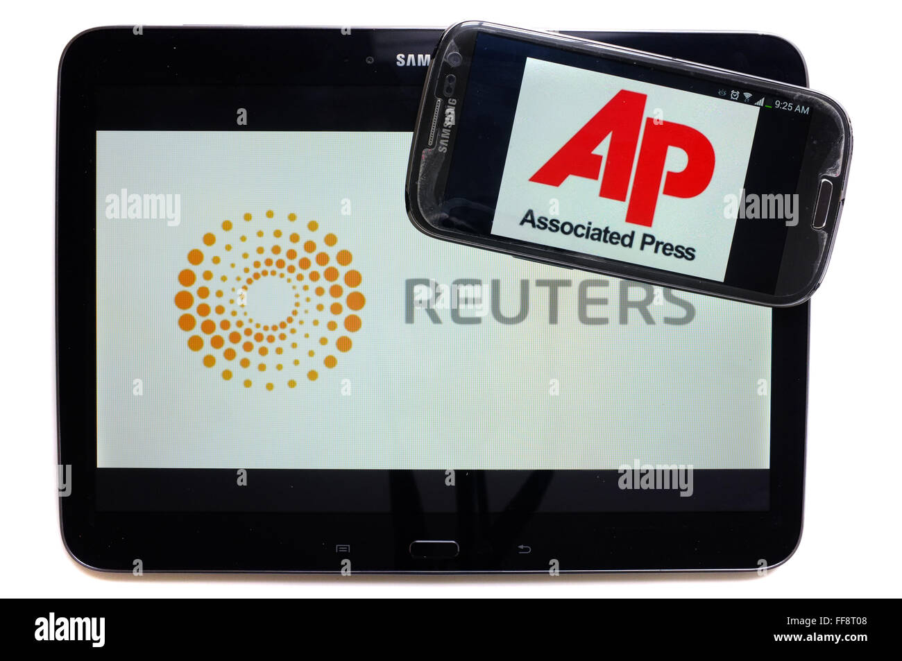 Le agenzie di notizie AP e Reuters sugli schermi di un tablet e uno smartphone fotografati contro uno sfondo bianco. Foto Stock