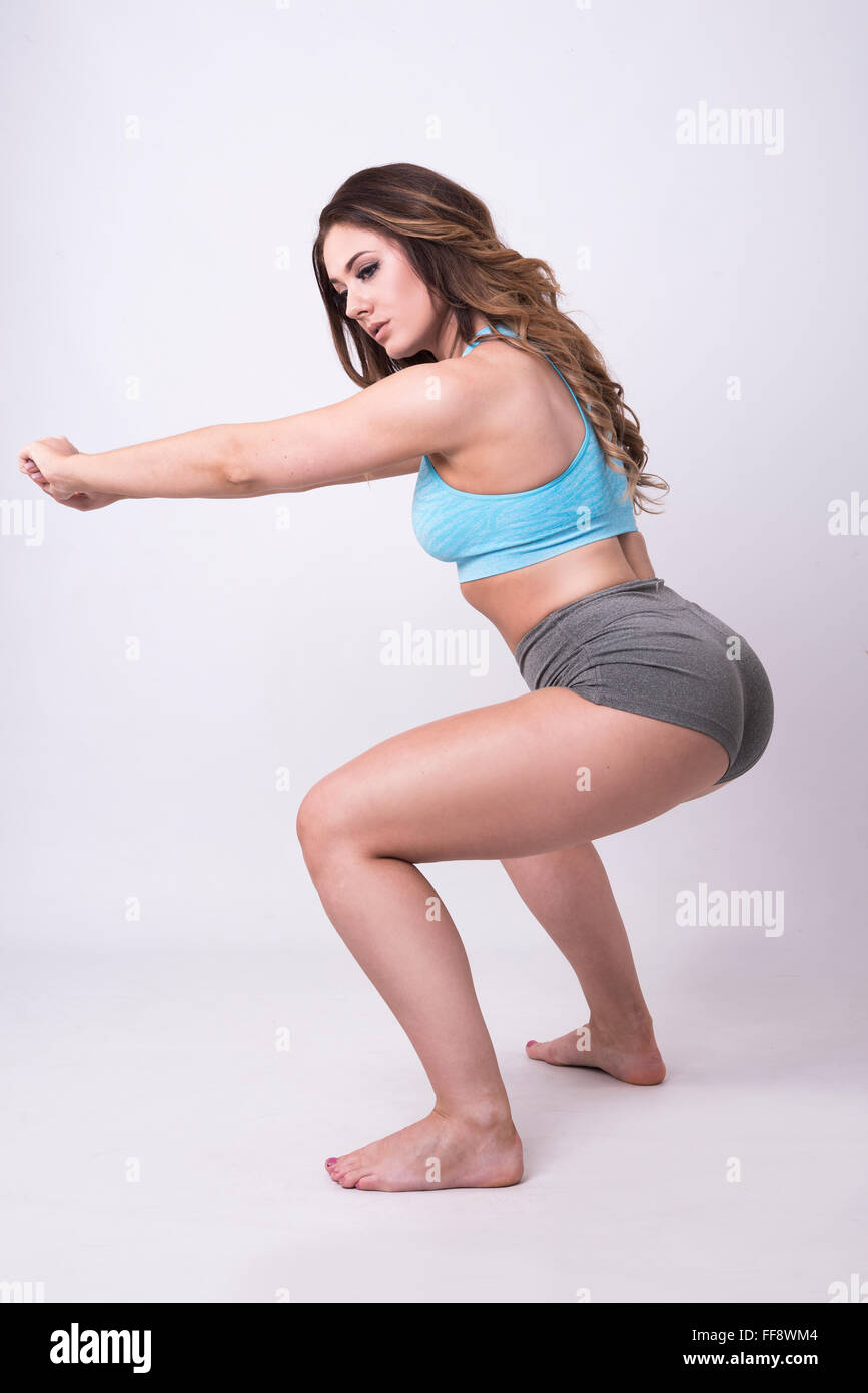 Modello facendo squat in palestra usura, fitness abbigliamento retro tonificante Foto Stock