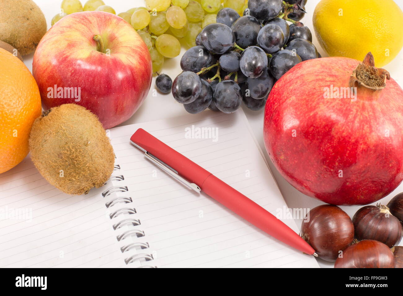 Grappolo di frutti e un notebook vuota Foto Stock