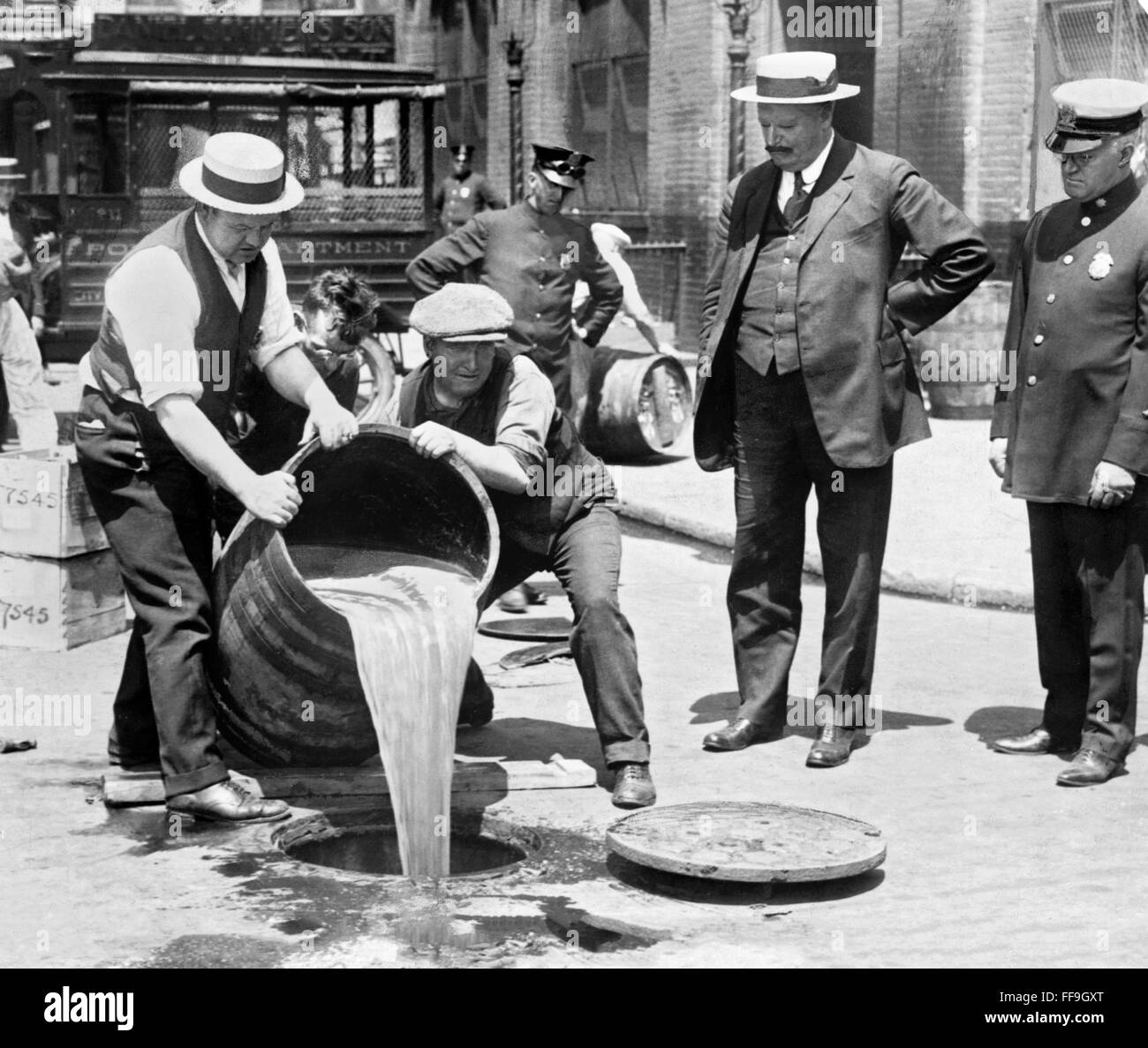 Divieto 1920s. Gli agenti di liquore di versatore in fogna a seguito di un raid durante probibition, New York City, NY, STATI UNITI D'AMERICA. Foto c.1921 Foto Stock