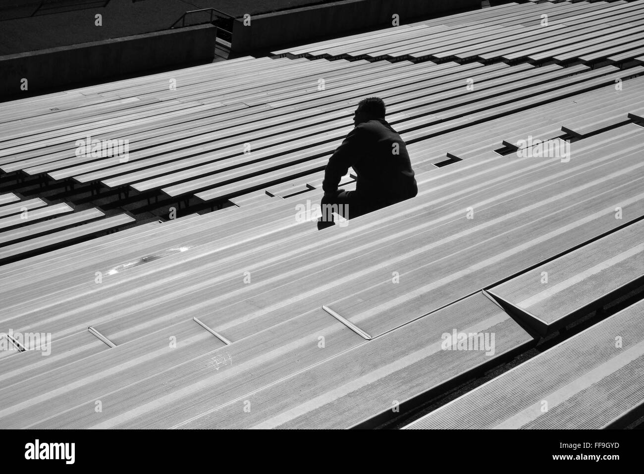 Lone persona seduta in tribuna Foto Stock
