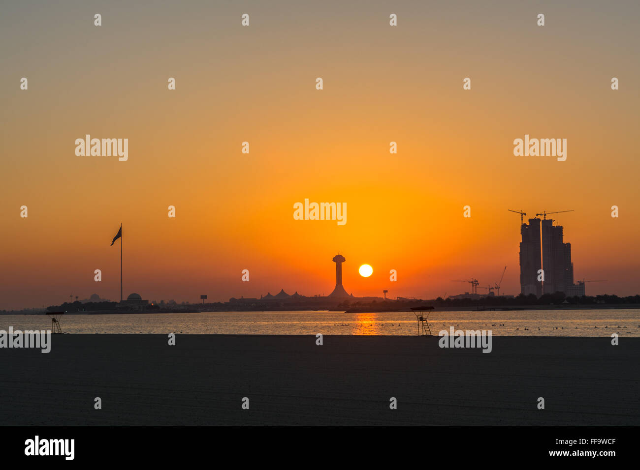 Città al lungomare spiaggia durante il tramonto Foto Stock