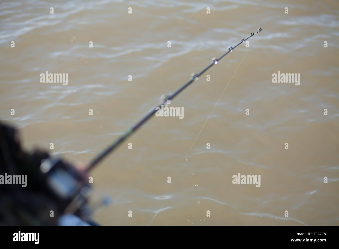 Close up di canna da pesca in acque torbide Foto Stock