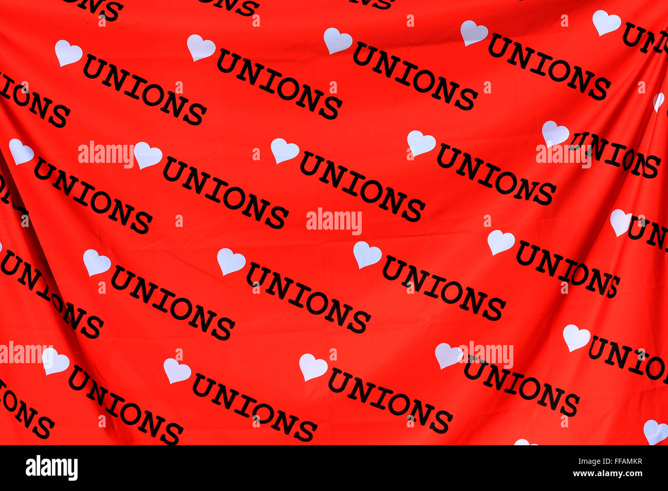 Amore sindacati banner in rosso in bianco e nero. Un sindacato banner drappeggiati in sunshine promuovere l amore per i sindacati nel Regno Unito Foto Stock