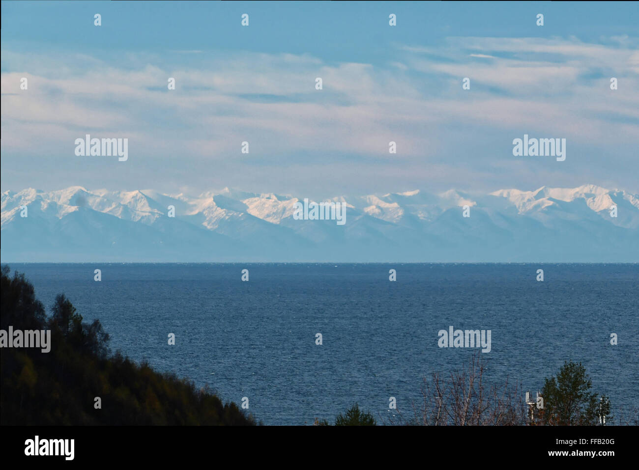 Guardando da Listvyanka sul lago Baikal in inverno verso Snow capped montuosa tutti con una sfumatura blu Foto Stock