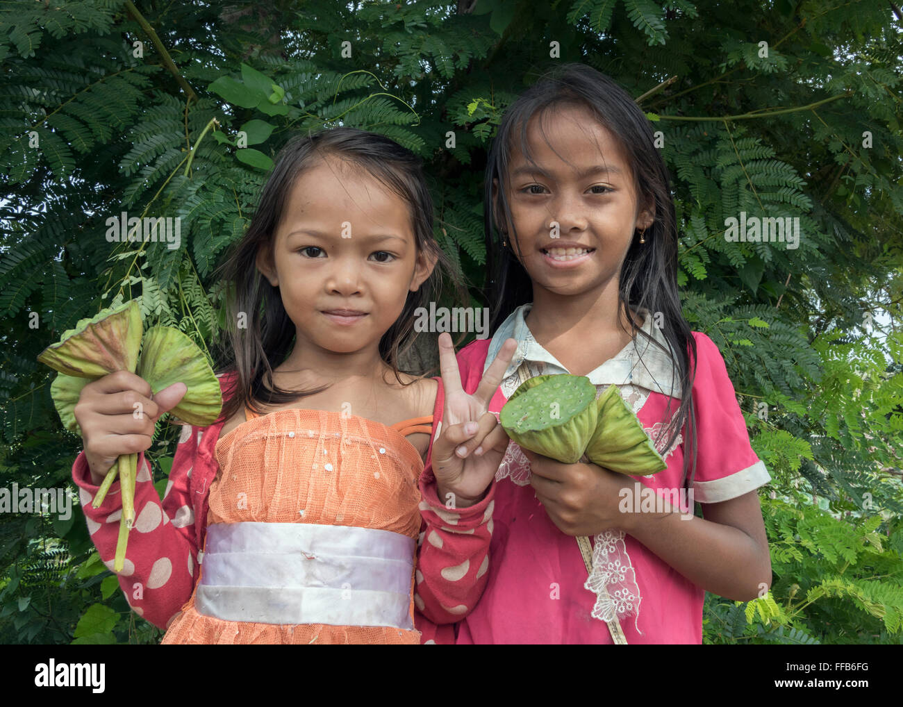 Due bambini di vendita di semi di loto baccelli, Samatoa Lotus Farm, Sangat Siem Reap, Cambogia Foto Stock