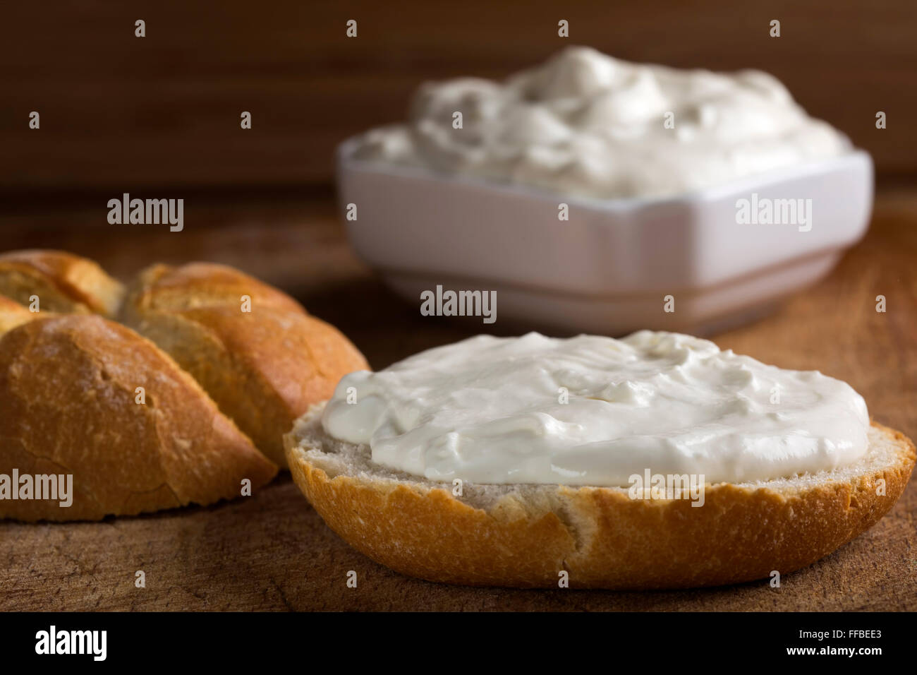 Organico sano grano intero bagel con formaggio spalmabile su sfondo di legno Foto Stock