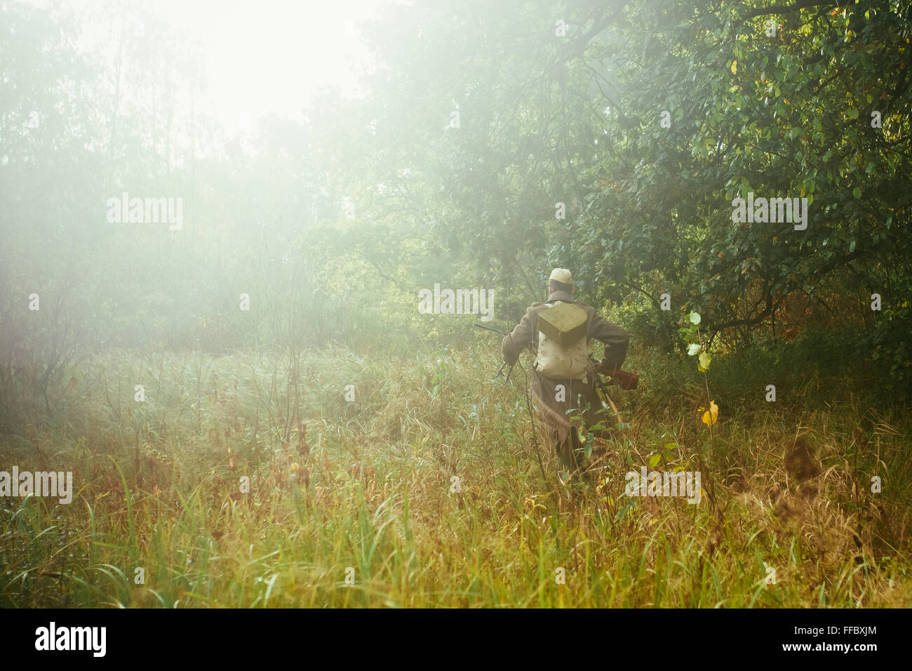 Unidentified ri-enactor vestita come la II Guerra Mondiale sovietica soldato russo in esecuzione con la mitragliatrice nella foresta di nebbia erba Foto Stock