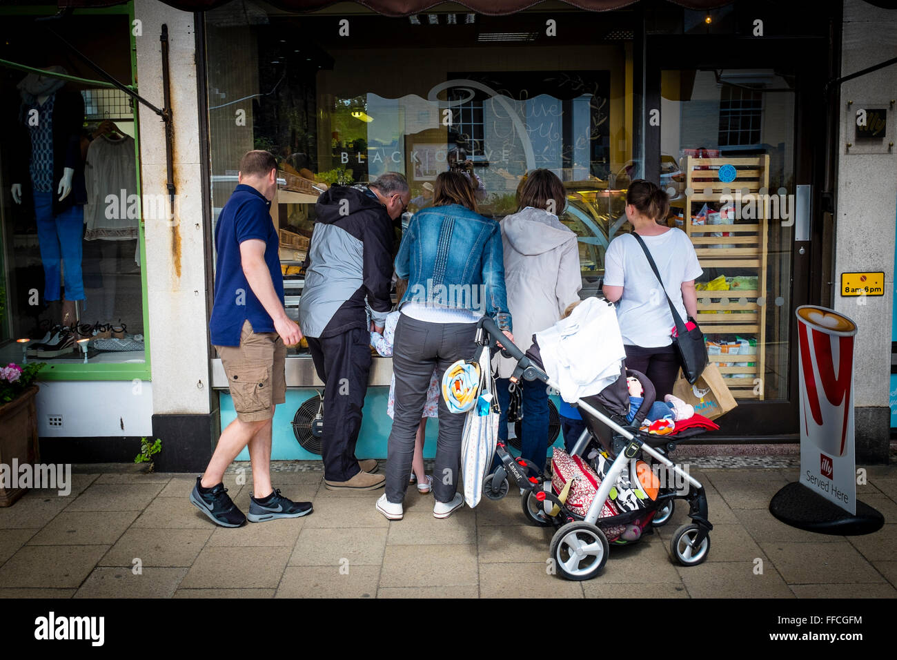 Gruppo di persone che guardano attraverso la finestra di un negozio, Southwold, Suffolk, Regno Unito Foto Stock