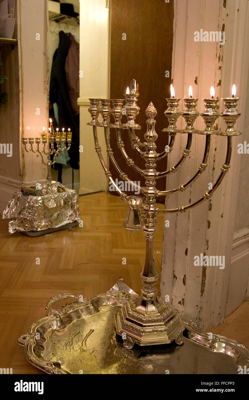 Chanukah dura per 8 giorni ed è la festa ebraica della luce. Essa commemora la riconsacrazione del tempio dopo che era stato profanato. Una candela è accesa ogni notte. Al fine di portare alla luce il mondo alcuni mettere le candele in loro vetri anteriori. Qui il 5° giorno di Chanukah menorahs sono collocati i portali di una famiglia locale. Foto Stock