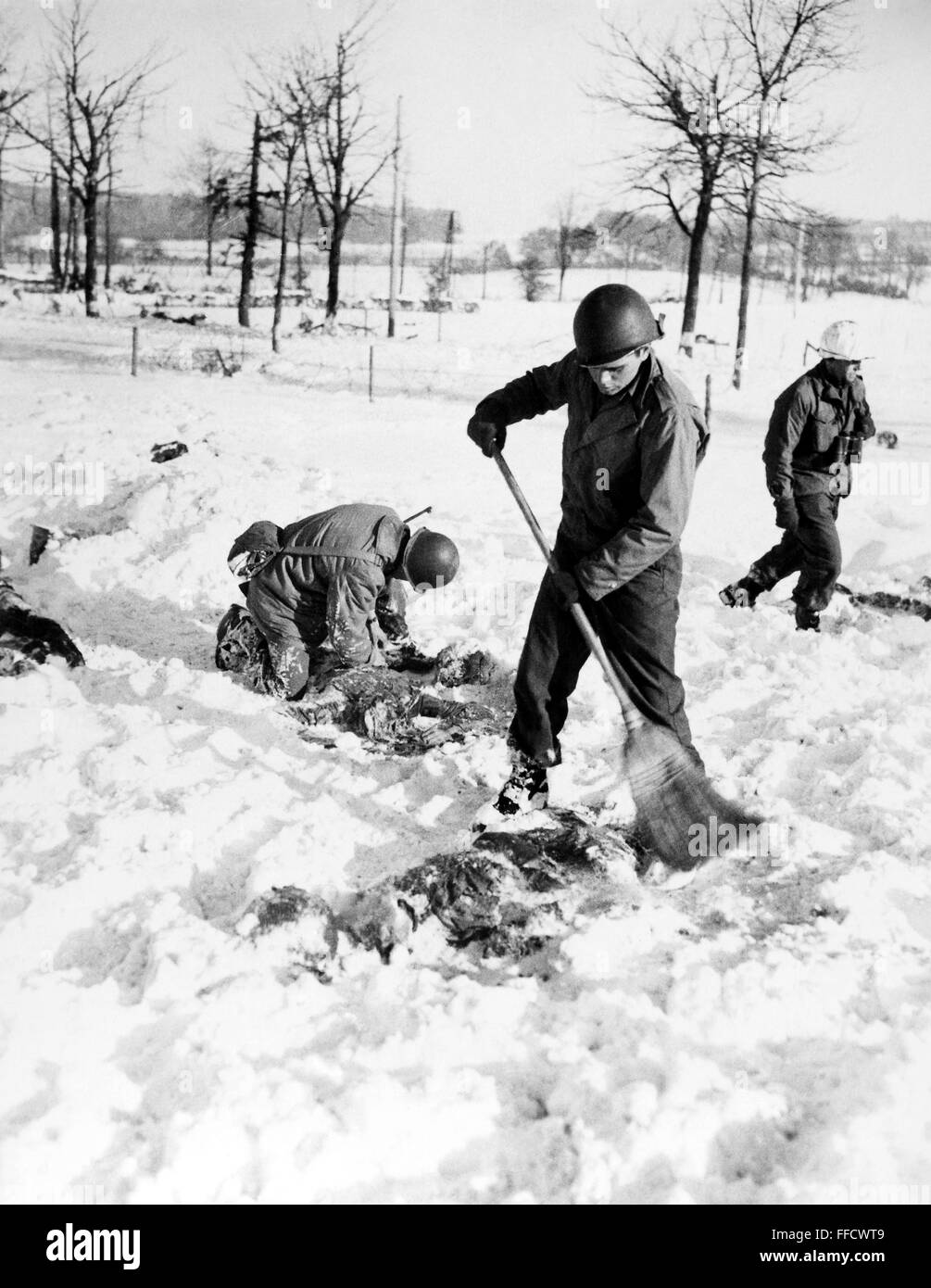 MALMEDY massacro, 1944. /NAmerican soldati recuperare i corpi dei loro compagni in una coperta di neve campo dopo che essi sono stati massacrati dai tedeschi Waffen-SS soldati vicino a Malmedy, Belgio, durante la II Guerra Mondiale, dicembre 1944. Foto Stock