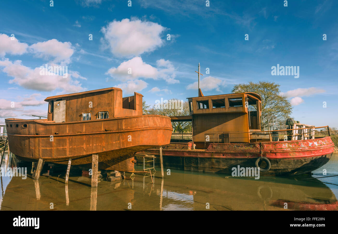 Abbandonata la ruggine barche di ferro che viene ripristinato sul fiume scafo su una luminosa giornata invernale a Beverley, nello Yorkshire, Regno Unito. Foto Stock