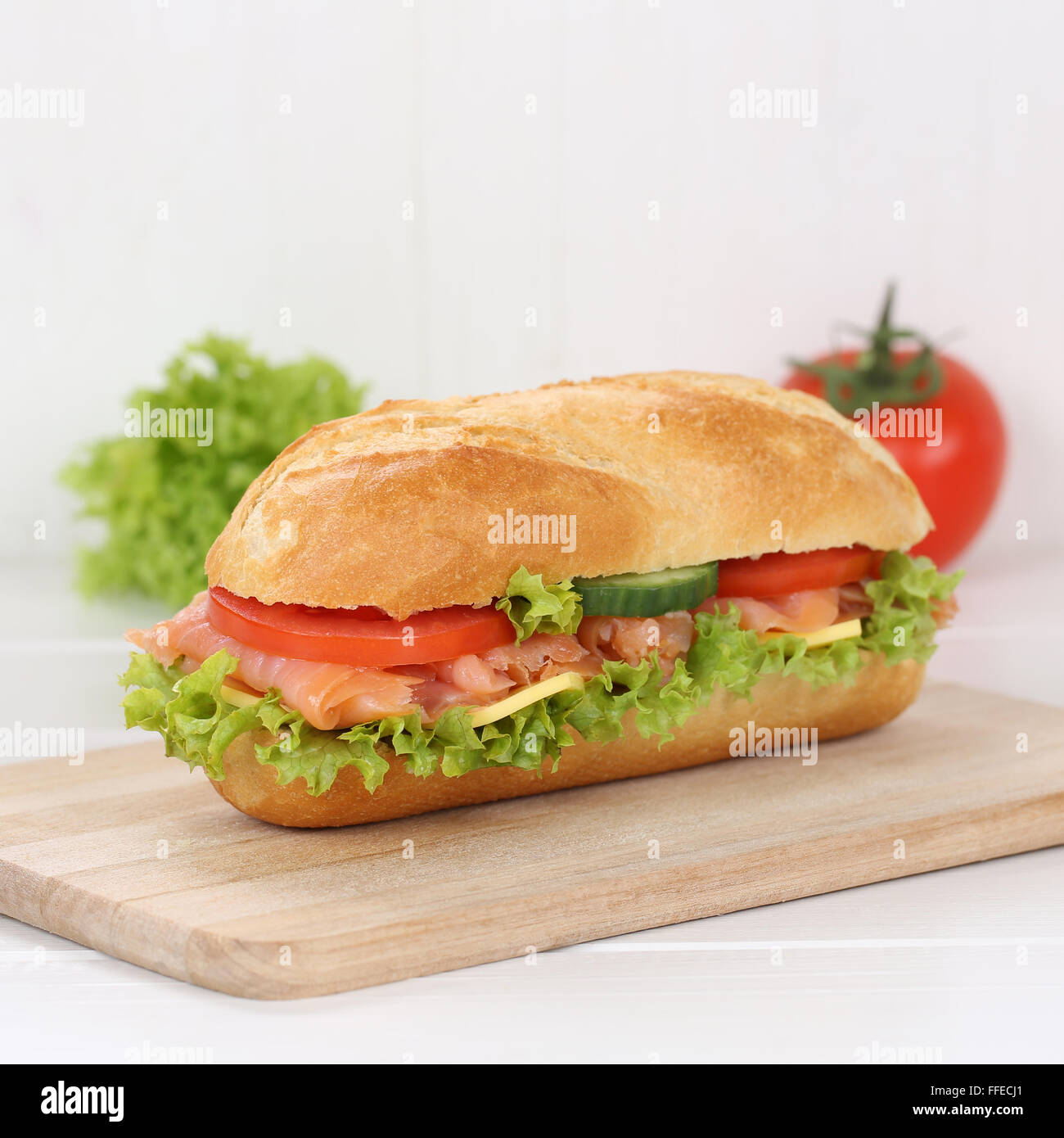 Mangiare sano sub deli sandwich baguette con salmone pesce, formaggio, pomodori e lattuga per la prima colazione Foto Stock