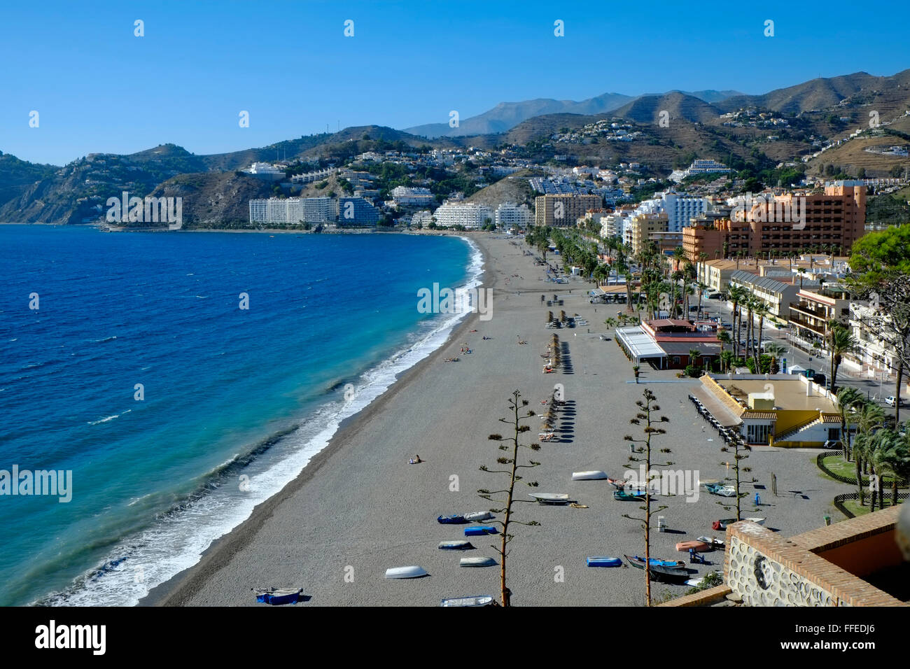 Il fronte spiaggia con bassi edifici e il blu ceruleo Mar Mediterraneo in un soleggiato tardo autunno giorno a Almuñécar, Costa Tropical, Andalusia. Spagna Foto Stock