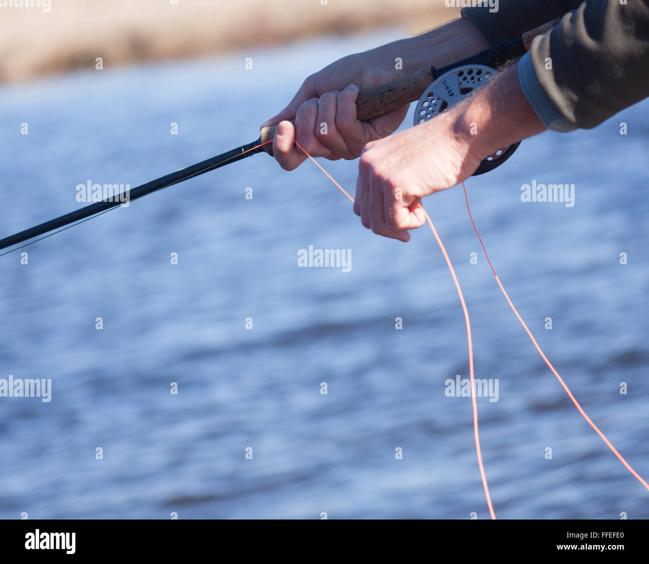 Chiusura del pescatore a mosca la linea di spelatura Foto Stock