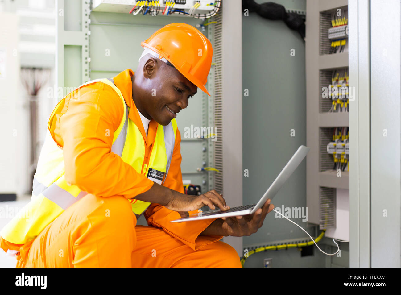 Giovane africana ingegnere americano utilizzando laptop in sala di controllo delle macchine Foto Stock