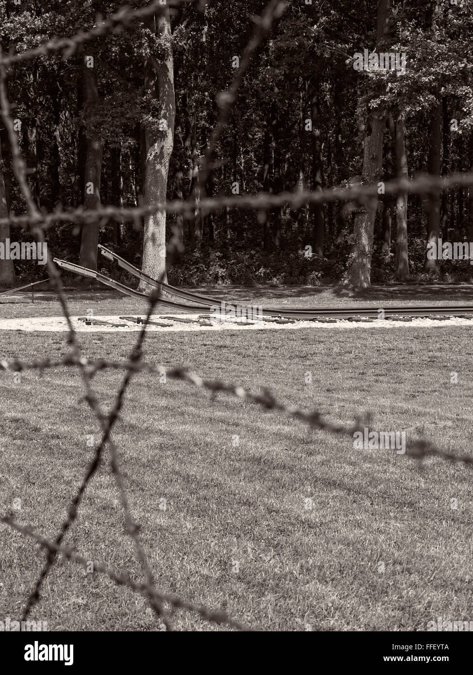 Vista attraverso il raccordo portagomma recinto di filo a ex nazista del campo di transito di Westerbork al binario ferroviario Foto Stock