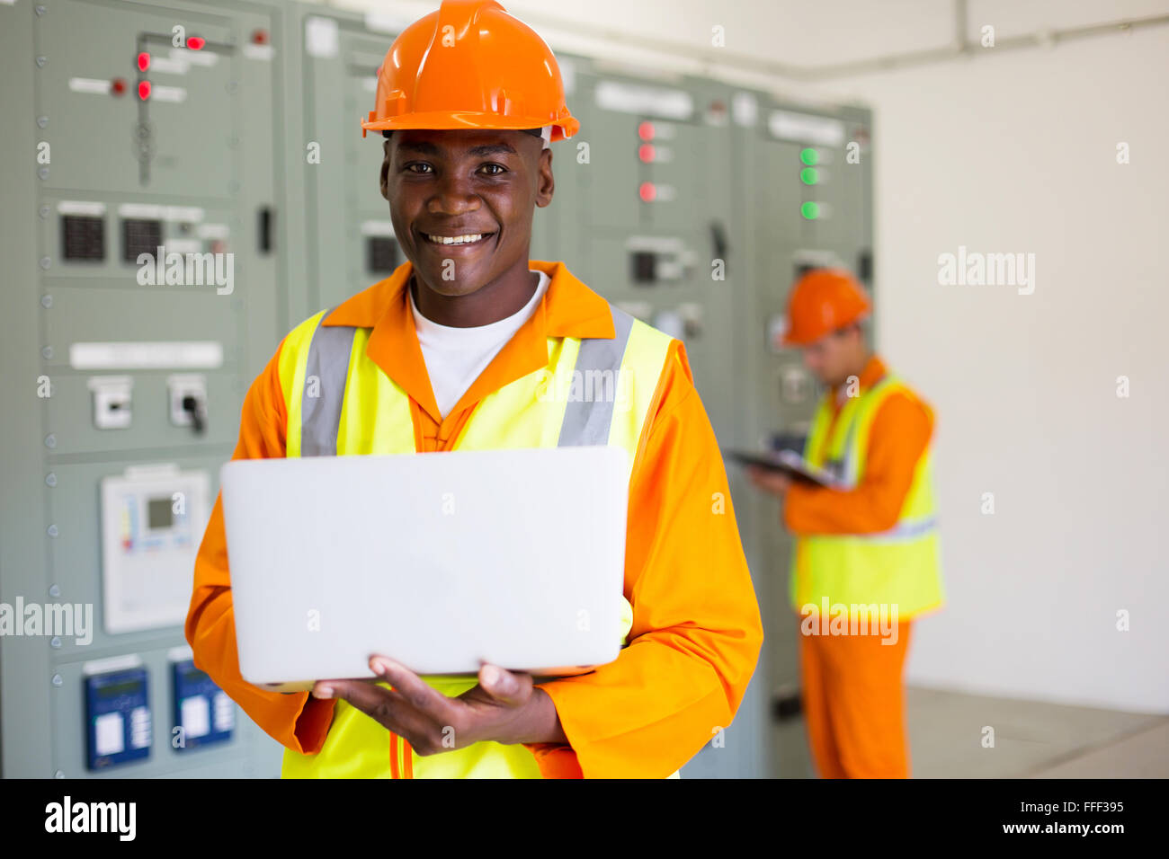 Ritratto di afro ingegnere americano utilizzando il computer portatile nella sala di controllo Foto Stock