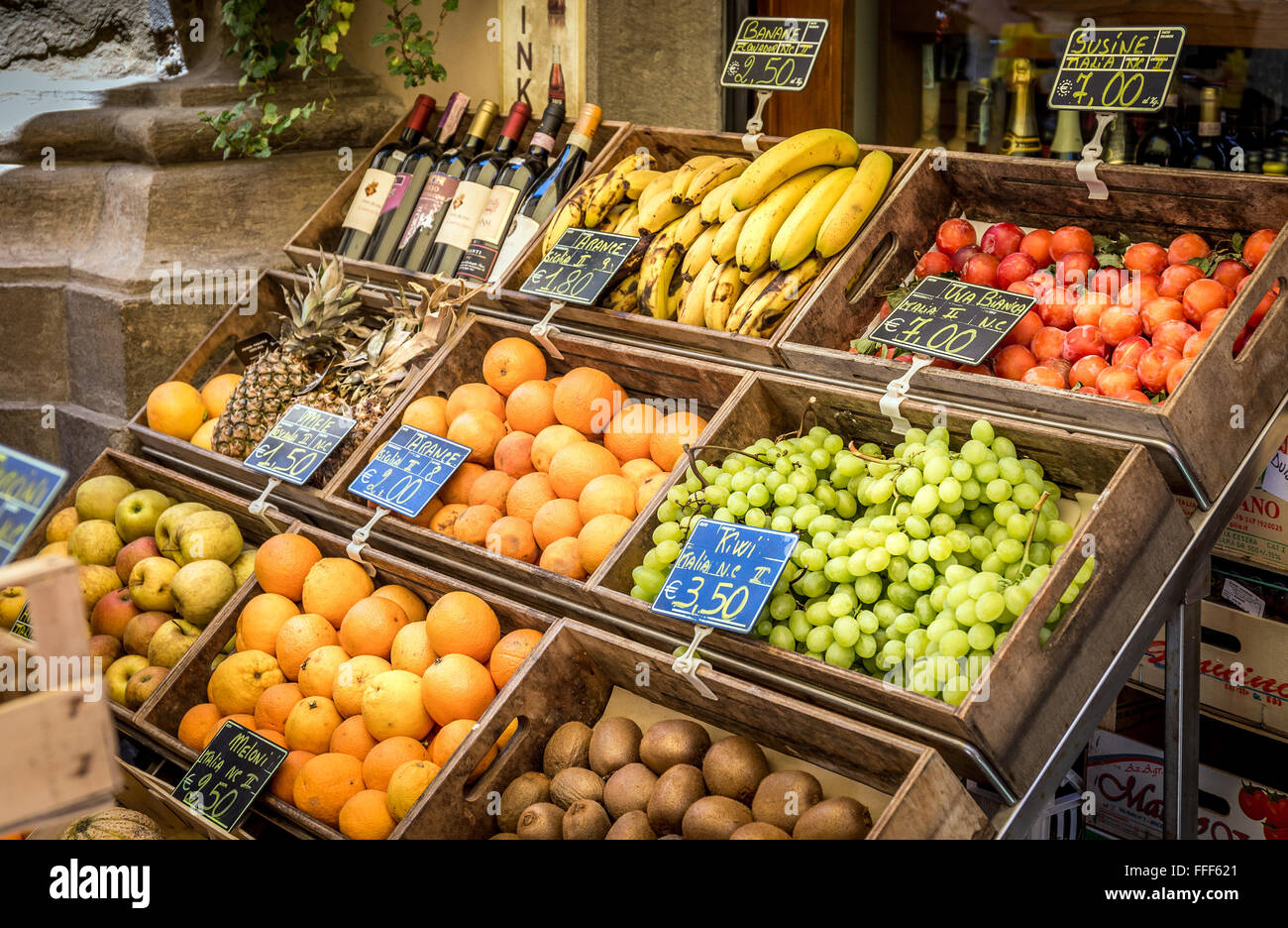 CORTONA, Italia - 26 giugno 2015: assortimento di toscane frutti maturi e le bottiglie di vino nella storica città di Cortona in Italia Foto Stock