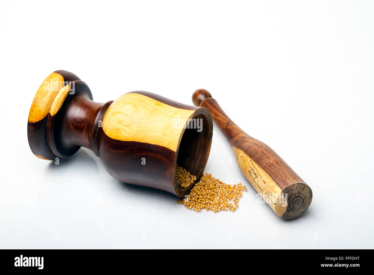 Un legno colorato mortaio e pestello con seme di senape Foto Stock