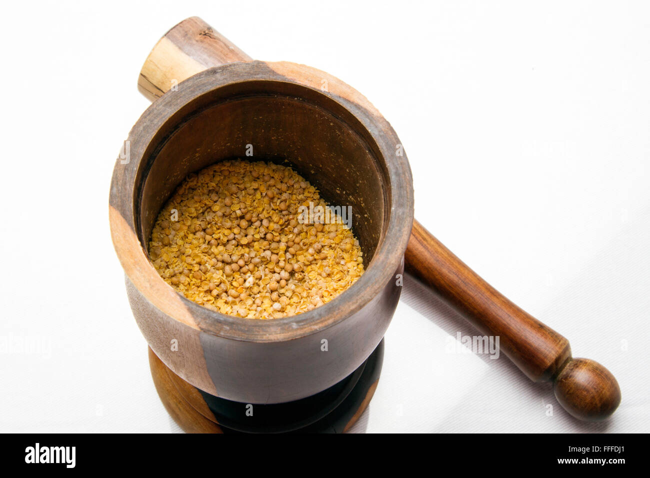 Un legno colorato mortaio e pestello con seme di senape Foto Stock