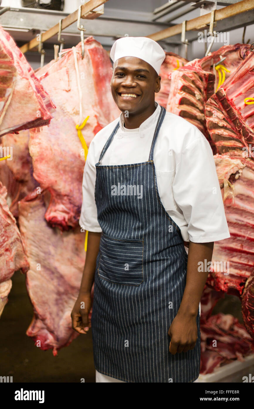 Sorridente African American macellaio in camera fredda Foto Stock