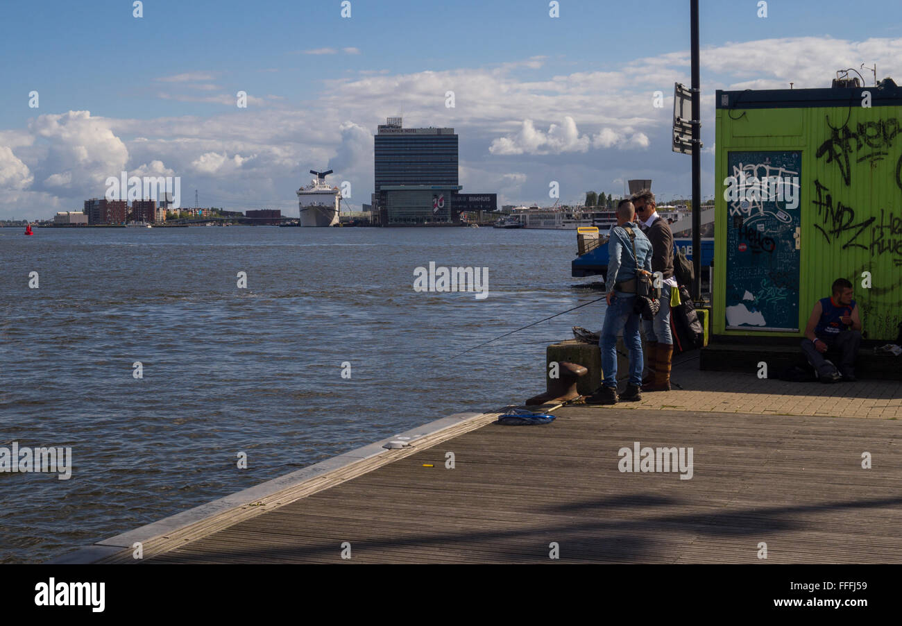 Gli uomini cattura del pesce al porto di Amsterdam Foto Stock