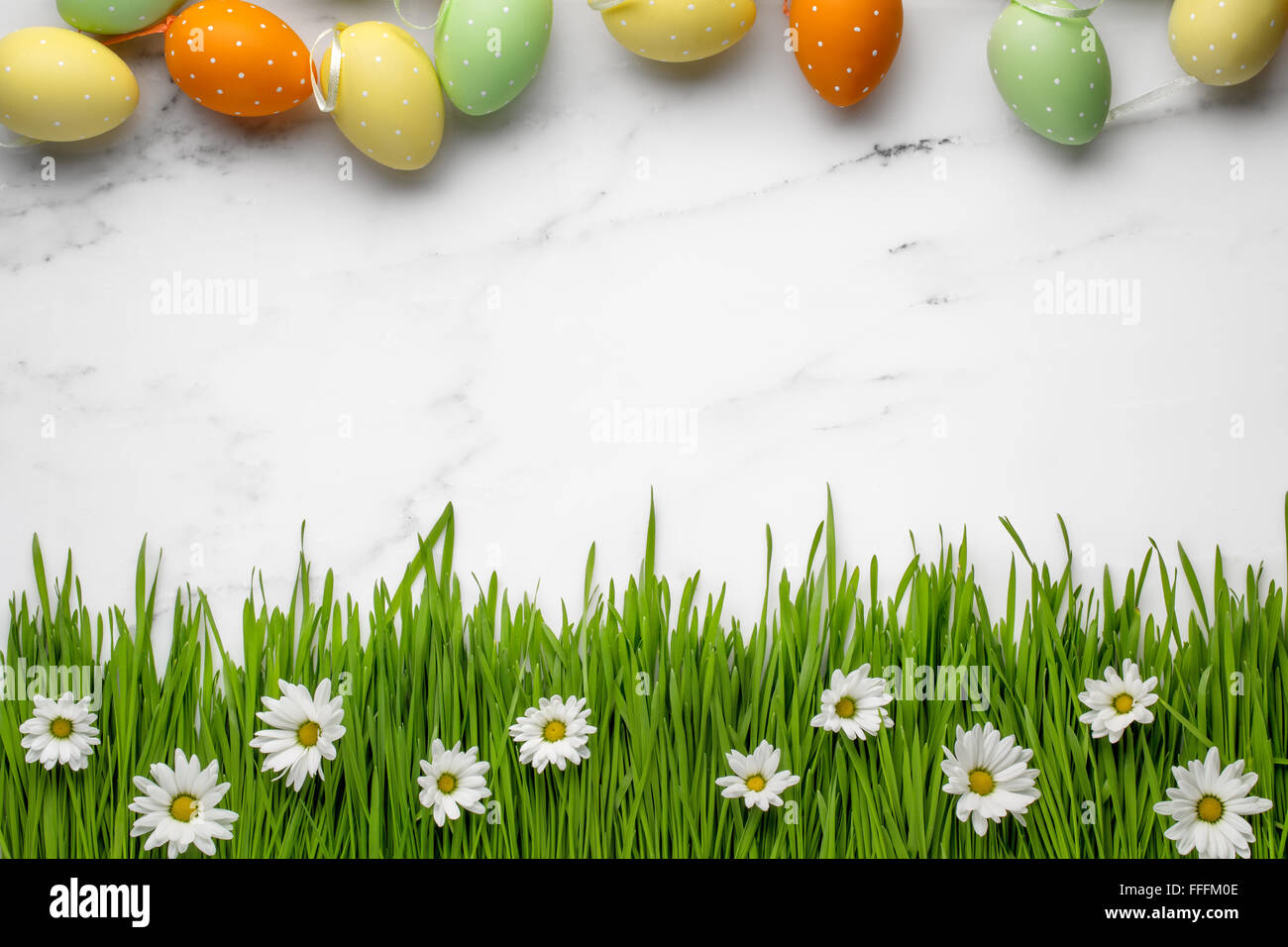 Le uova di pasqua,l'erba verde con fiore a margherita su Sfondo marmo Foto Stock