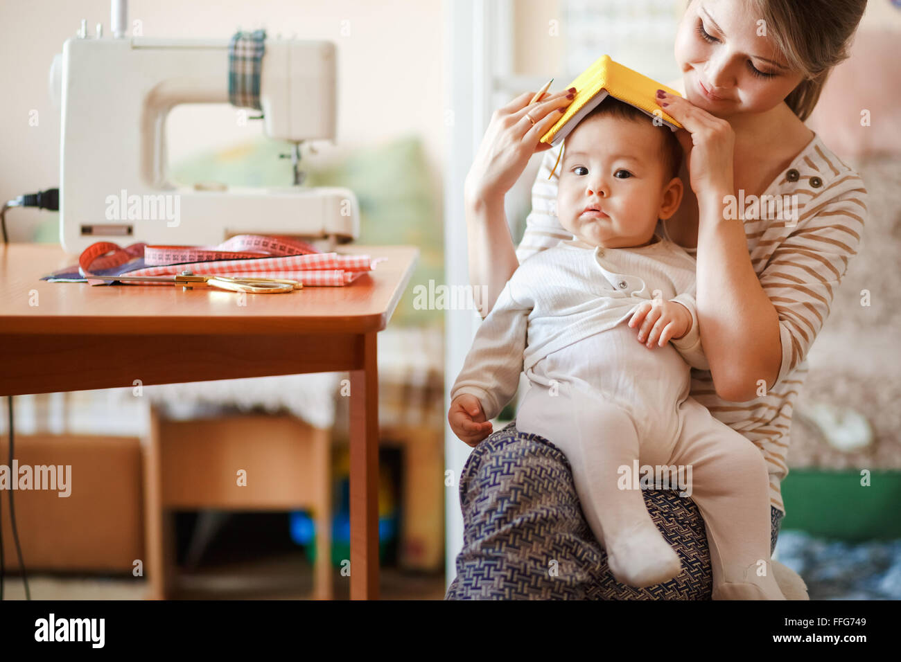Per allevare i figli, cura dei bambini, baby sitter. La madre e il bambino a casa la riproduzione di giochi di ruolo. Carino parenting divertenti. Foto Stock