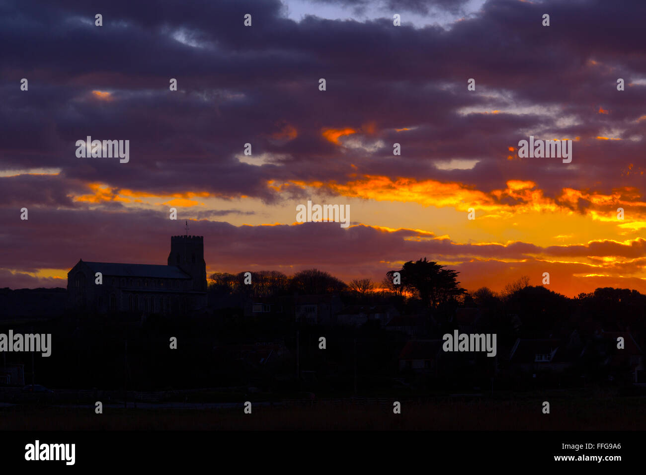 Salthouse villaggio chiesa e paludi allagate in primo piano al tramonto Foto Stock