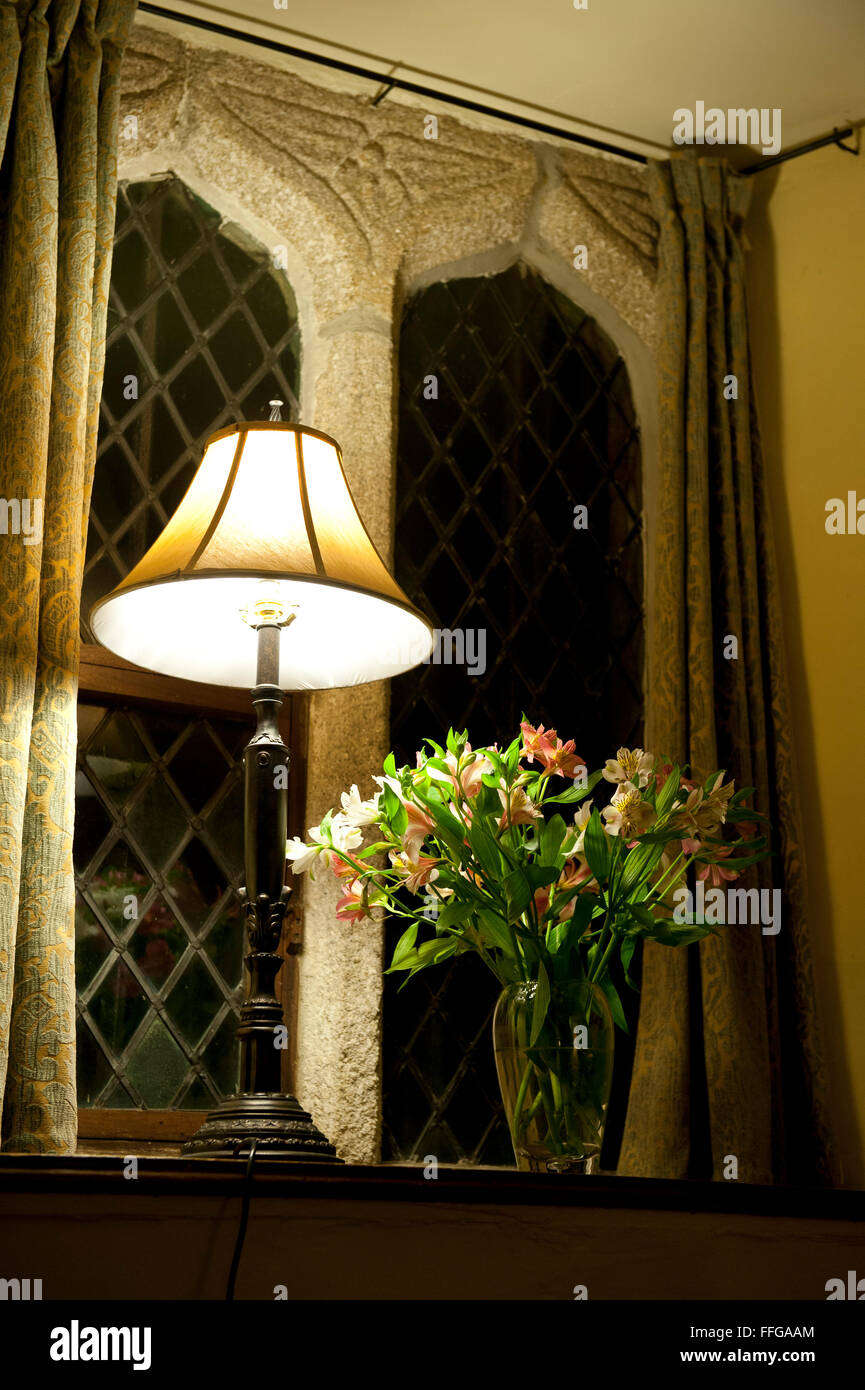 Lampada Standard e bouquet di fiori sul davanzale della vecchia casa medioevale di notte Inghilterra UK Europa Foto Stock