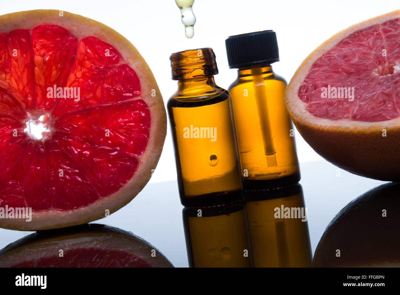 Olio essenziale flacone di vetro ambrato con fette di pompelmo, con contagocce Foto Stock