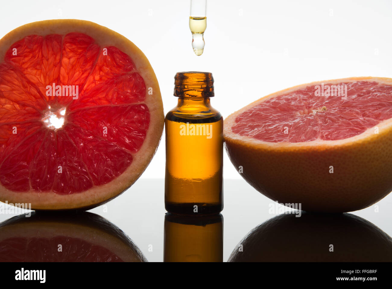 Olio essenziale flacone di vetro ambrato con fette di pompelmo, con contagocce Foto Stock