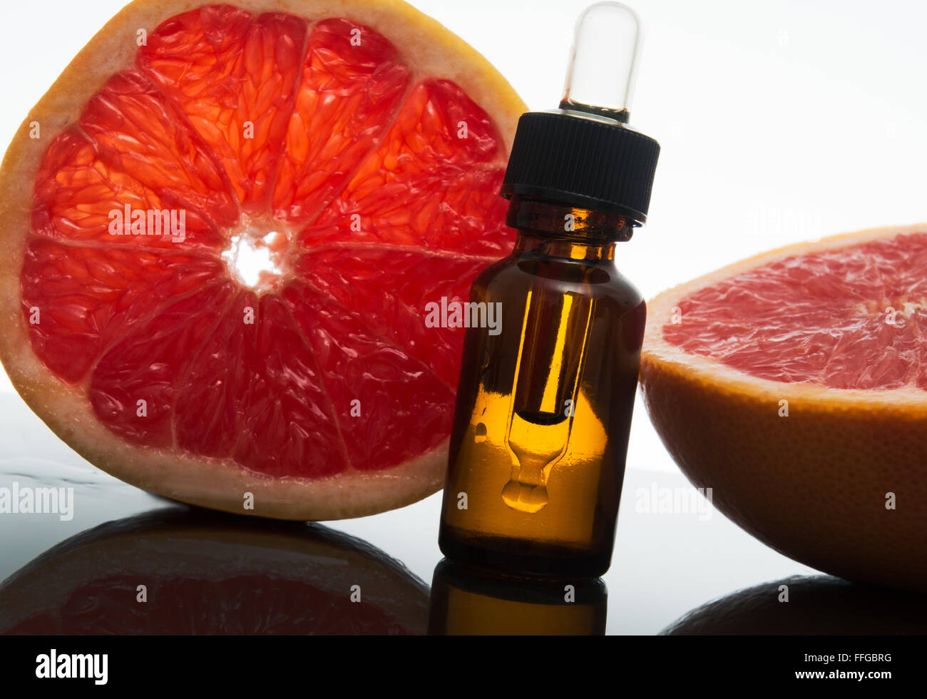Olio essenziale flacone di vetro ambrato con fette di pompelmo, con contagocce Foto Stock