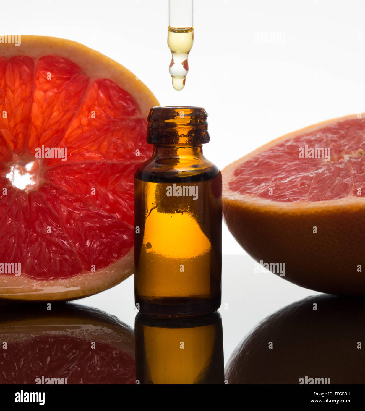 Olio essenziale flacone di vetro ambrato con fette di pompelmo, con contagocce Foto Stock
