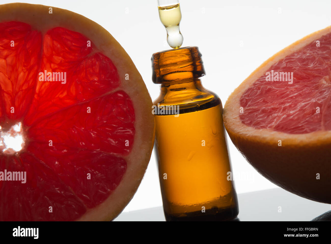 Olio essenziale flacone di vetro ambrato con fette di pompelmo, con contagocce Foto Stock