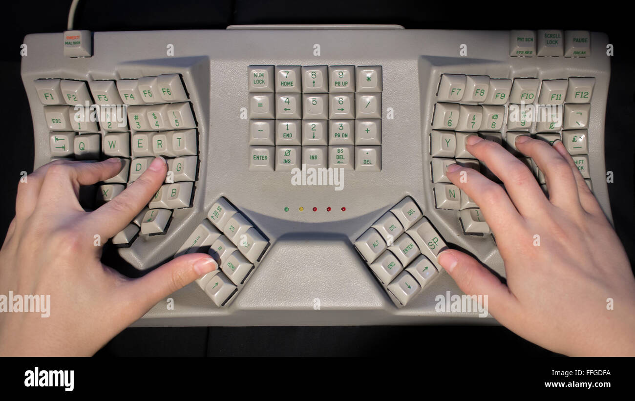 Mani digitando su un design ergonomico "Split keyboard' progettato per evitare lesioni da sforzo ripetitivo. Foto Stock