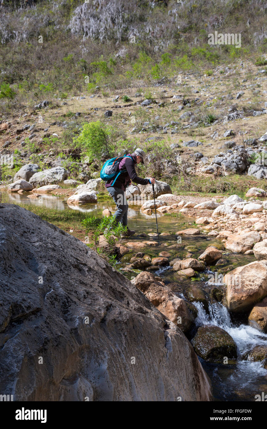 Santiago Apoala, Oaxaca, Messico - un turista attraversa un ruscello vicino al villaggio di Apoala, un piccolo paese di montagna. Foto Stock