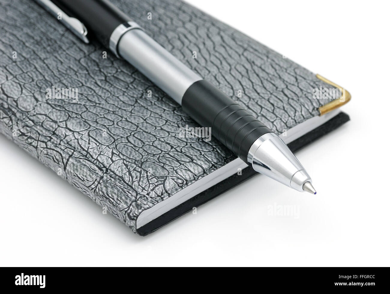 Un quaderno e una penna isolata su uno sfondo bianco Foto Stock