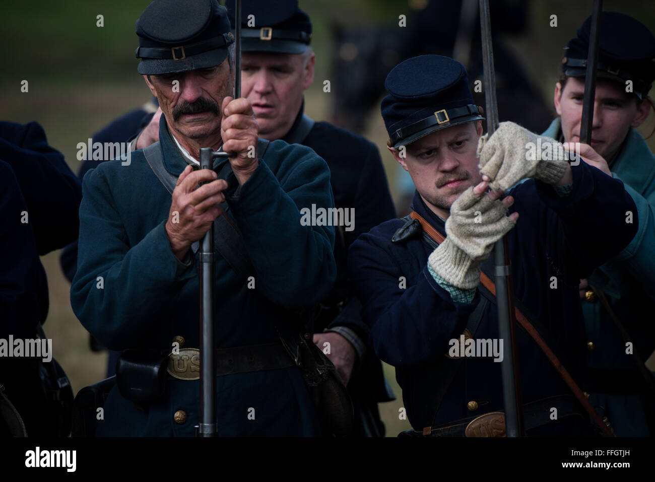 Forze dell'Unione re-enactors preparare i loro fucili collegando nel loro baionette prima della battaglia di Cedar Creek vicino a Middletown, Virginia. Centinaia di re-enactors in tutto il paese ha partecipato la 151st anniversario della battaglia. Foto Stock