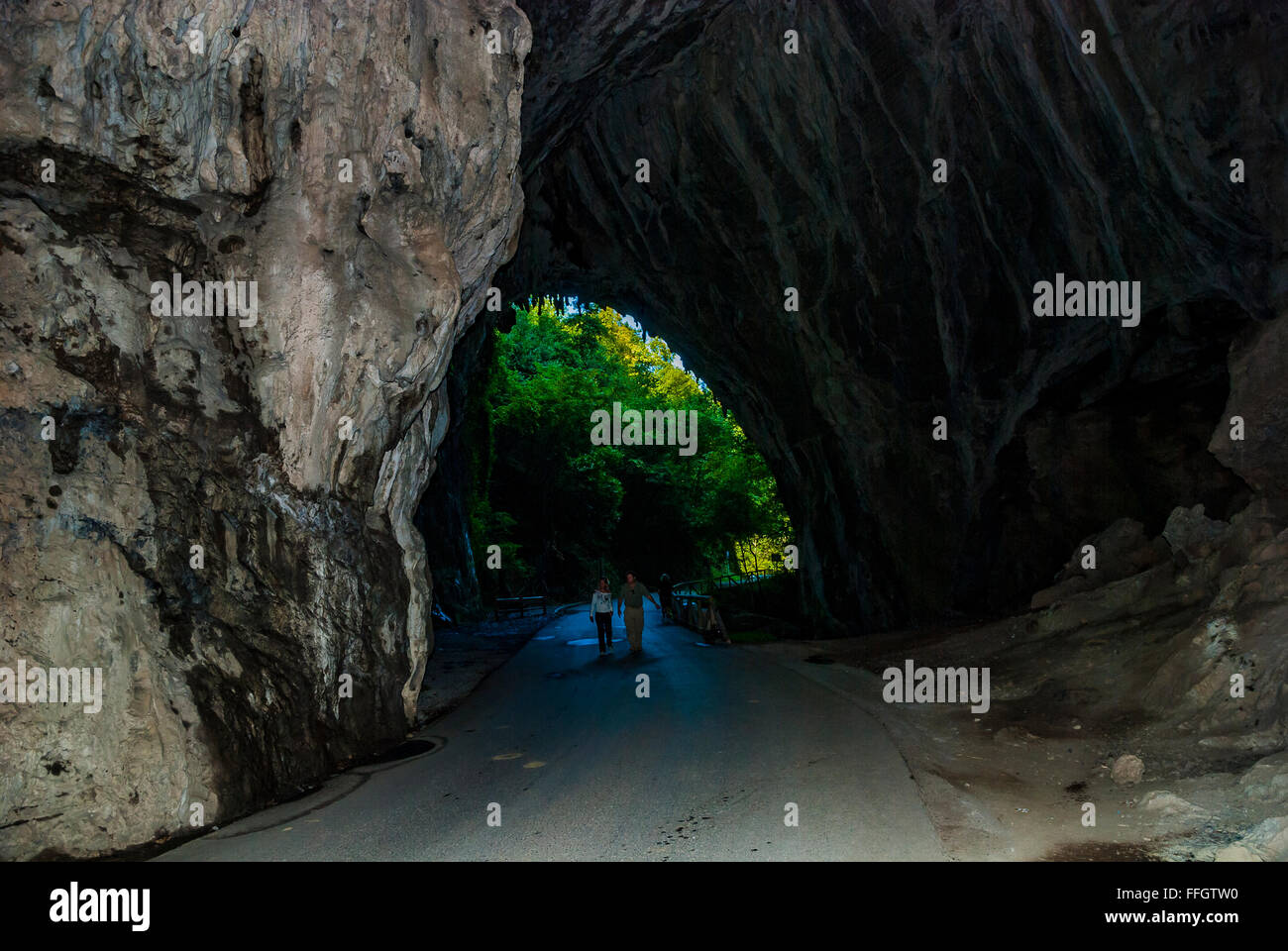 La Cuevona, tunnel naturale che attraversa la strada a Cuevas del Agua. Rivadesella, Asturias, Spagna Foto Stock