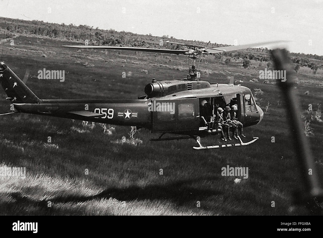 Vietnamese Air Force personale della 211th squadrone di elicotteri volare su un Combat Assault missione in un UH-1 Huey oltre il sud-est asiatico nel luglio 1970. Foto Stock