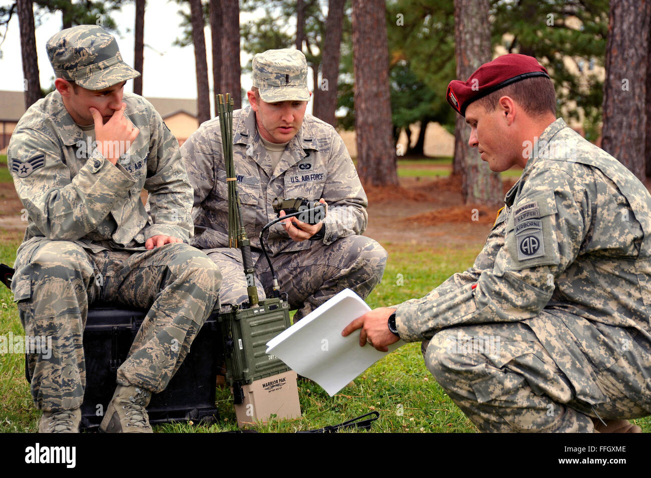 Il Senior Airman Dustin Harris e il primo tenente John Day, entrambi membri del 14th Air Support Operations Squadron, discutono del frequency hopping con un soldato della 82nd Airborne Division. Il frequency hopping è una tecnica radio utilizzata per mantenere la sicurezza delle comunicazioni durante le trasmissioni. Foto Stock