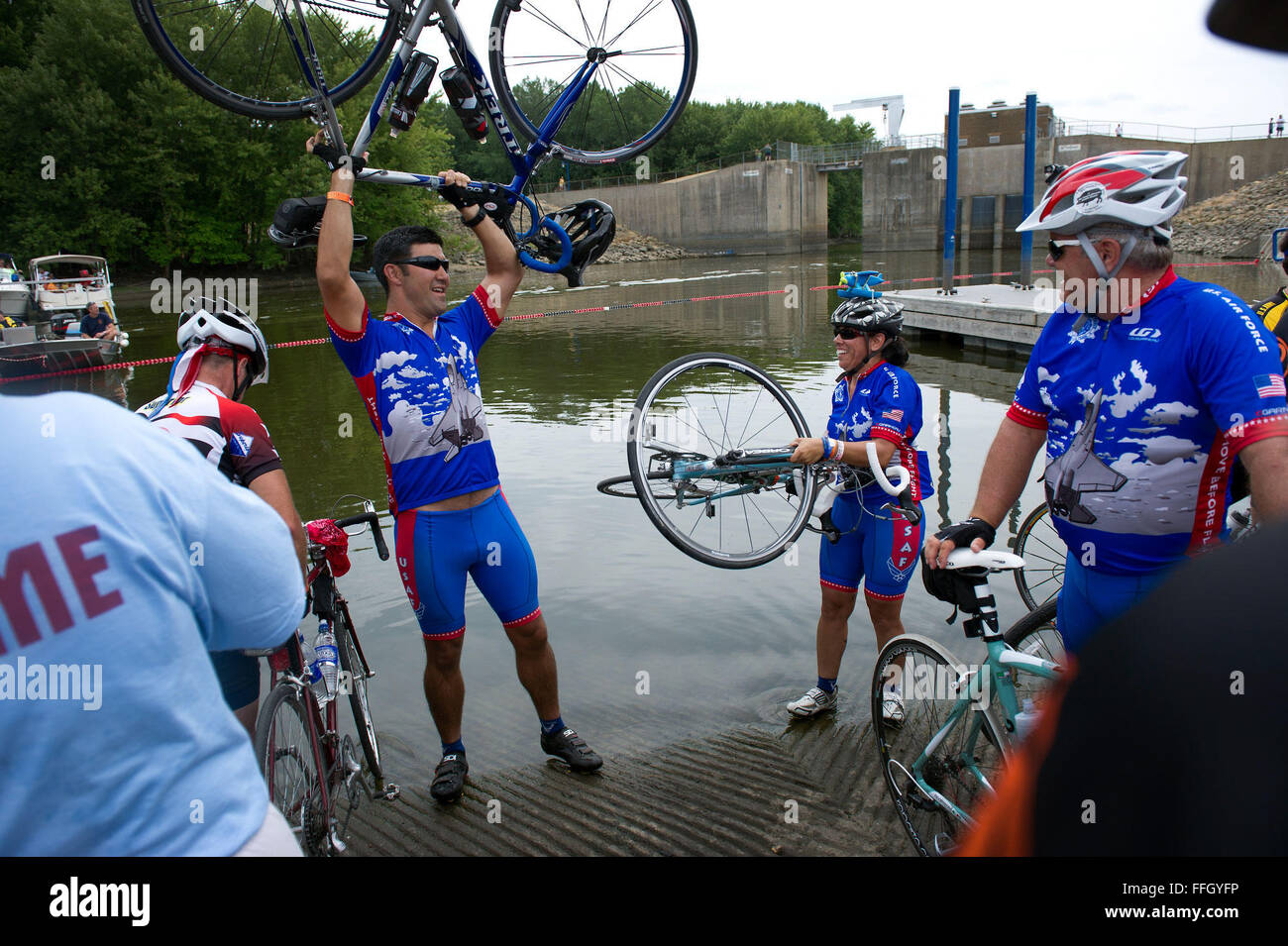 Membri della RAGBRAI Air Force Team Ciclo di immergere i loro pneumatici nel fiume Mississippi a indicare la fine della corsa in Clinton, Iowa. Piloti anche immerso di pneumatici per il fiume Missouri all'inizio della corsa. Foto Stock