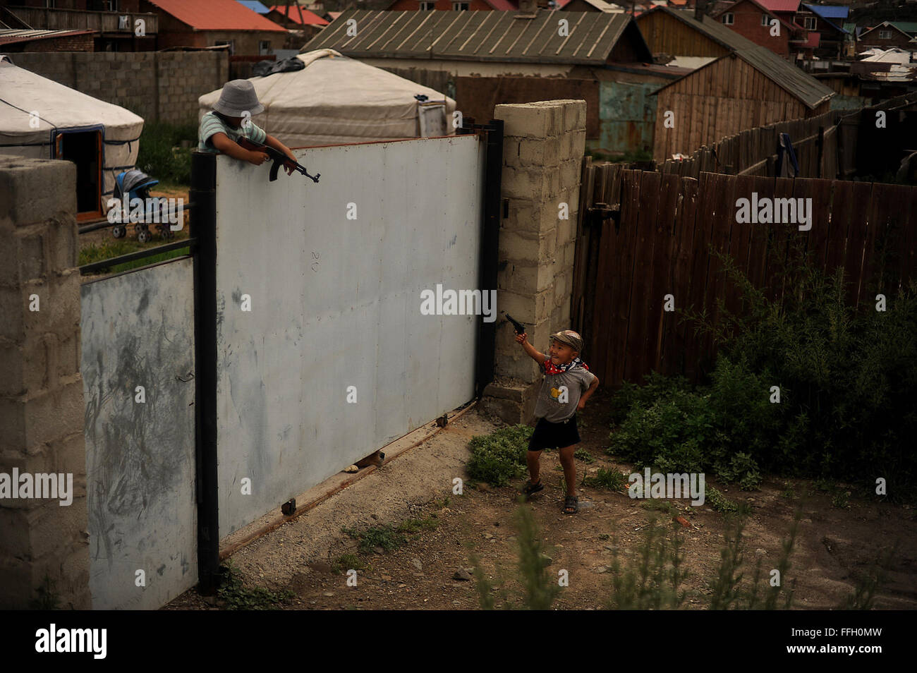 Due giovani ragazzi correre e giocare con pistole giocattolo Luglio 28, 2012, in ger del distretto di Ulaanbaatar, in Mongolia,. Ger distretti solitamente occupano scarsa qualità del terreno sulla periferia della città. Foto Stock