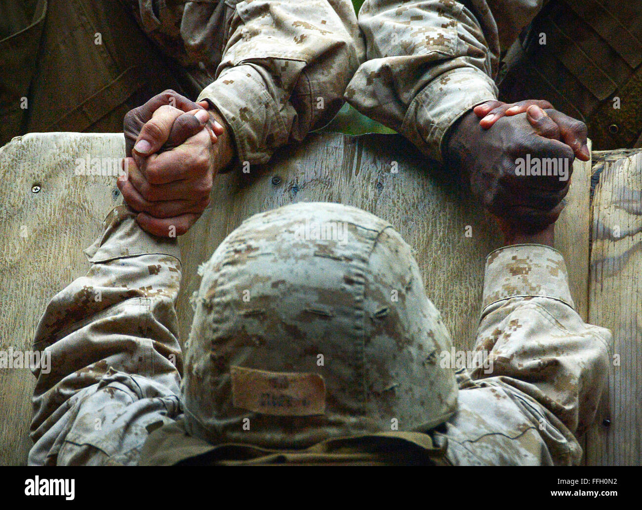 Reclute dalla società C. aiutare un compagno di reclutare salire un 8 piedi di parete in corrispondenza di Parris Island, S.C., Dic 14, 2012. La recluta ha partecipato al "crogiolo", un evento di due giorni che richiede il futuro marines a marzo 50 o più miglia, mentre utilizzando il lavoro di squadra per completare le attività di fronte ad essi. Questo compito impegnativo è l' ultimo ostacolo messo loro in modo prima di ricevere l'aquila, Globe, e ancoraggio, e conquistando il titolo "Marina" per la prima volta. Foto Stock